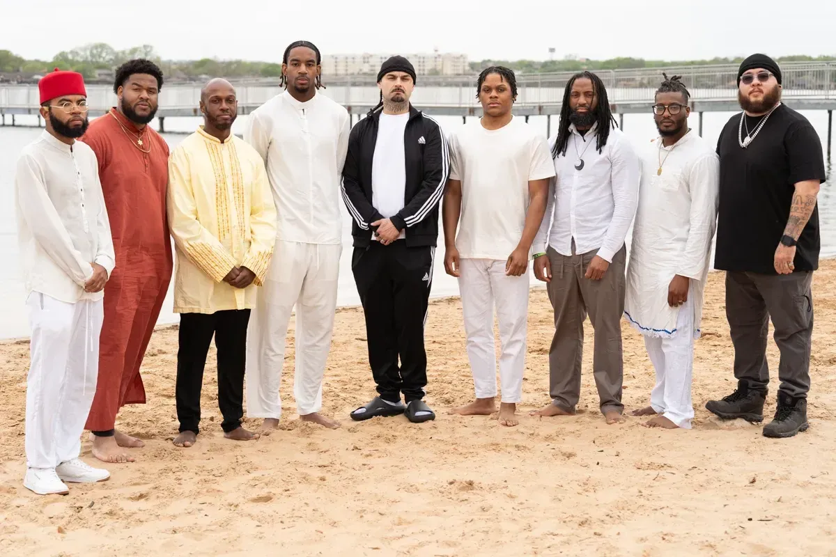 Men of the congregation standing together on the beach after immersions.