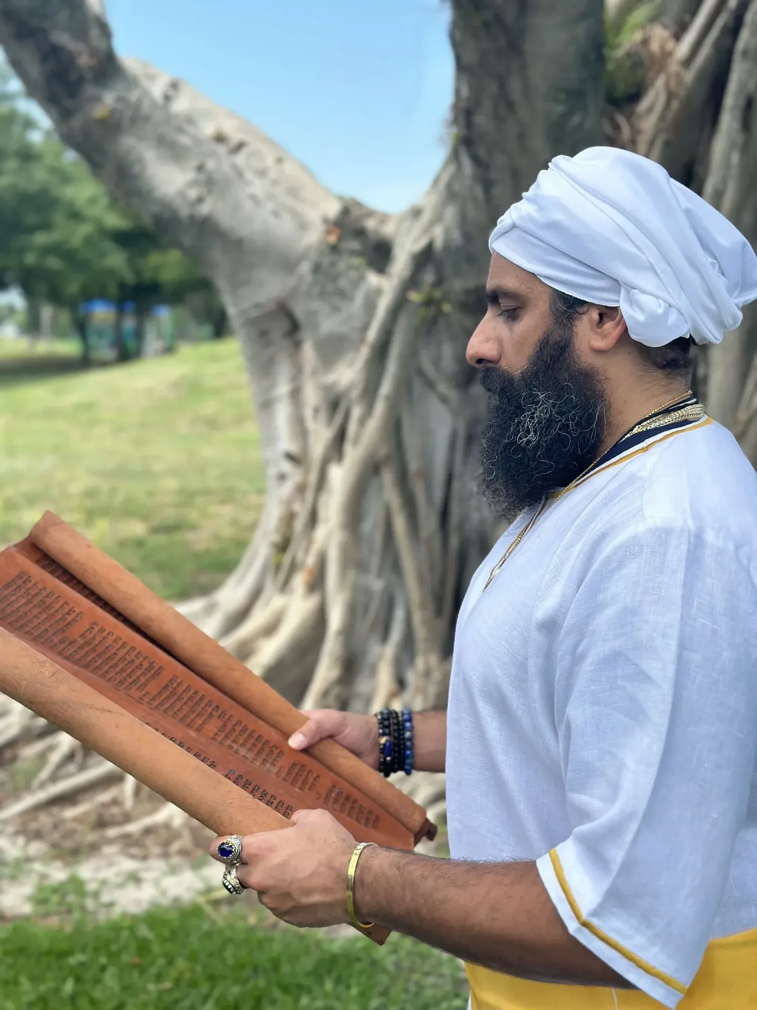 Rab Kahana Yamin Ben-EL reading from a scroll beneath a tree.