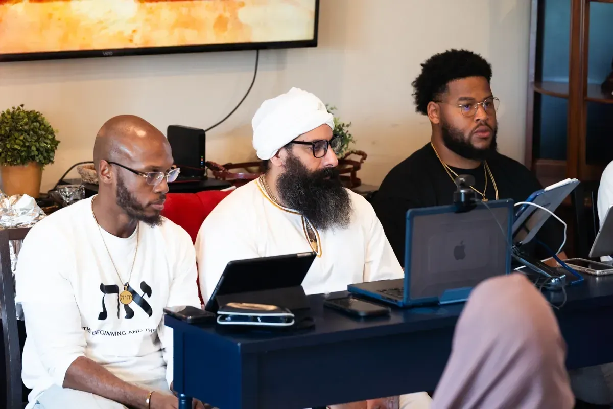 Rab Kahana Yamin Ben-EL teaching at a table with leaders of the congregation.