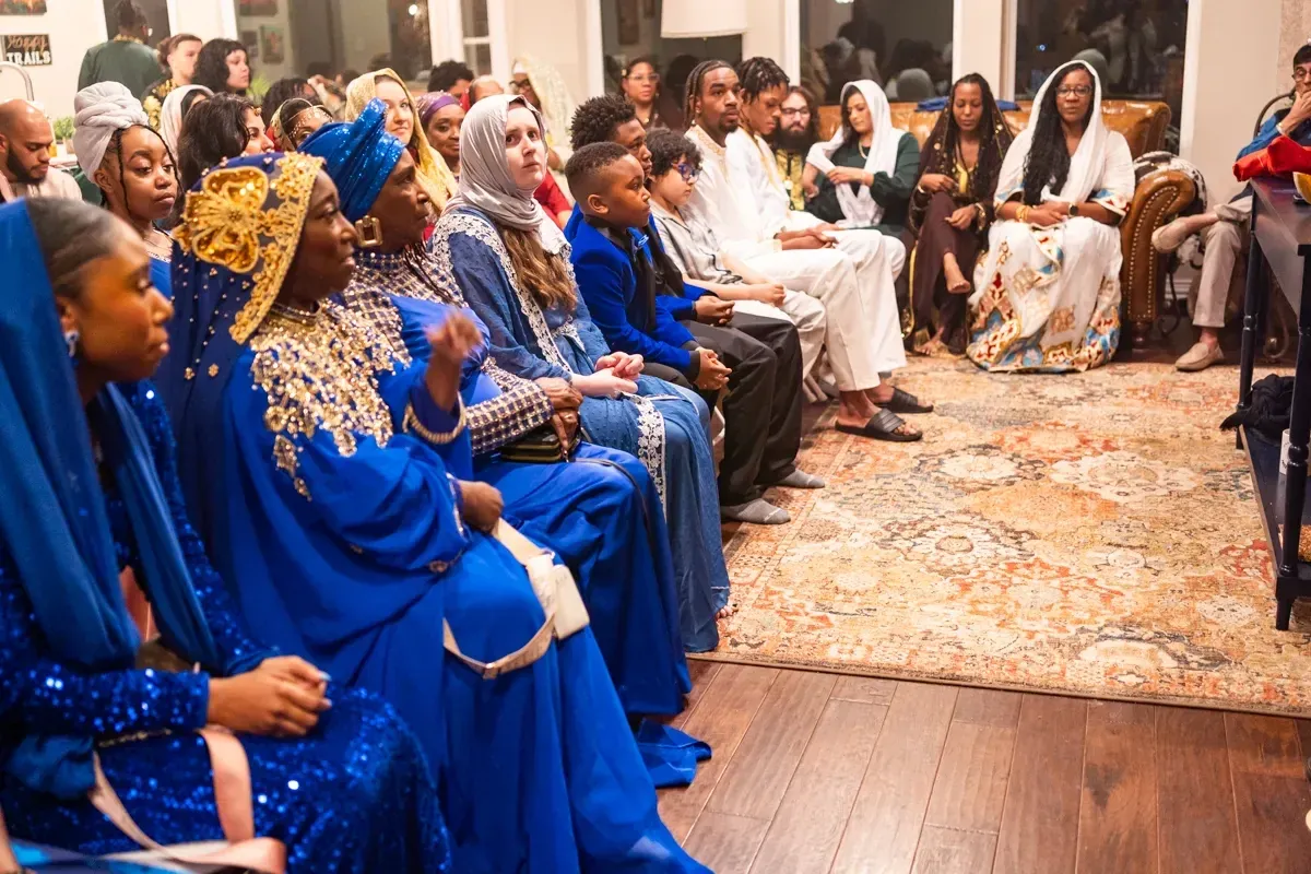 Women of the congregation in blue and gold garments seated for worship.